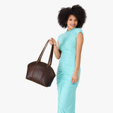 Coldbrew Large | Model holding a half circle crossbody bag with handles and removable crossbody strap 