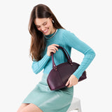 Larkspur Small | Model holding a half circle crossbody bag with handles and removable crossbody strap 