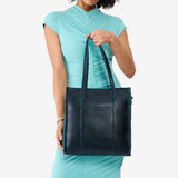 Boreal North/South | Model holding structured wide tote bag with overlapping panels and crossbody strap