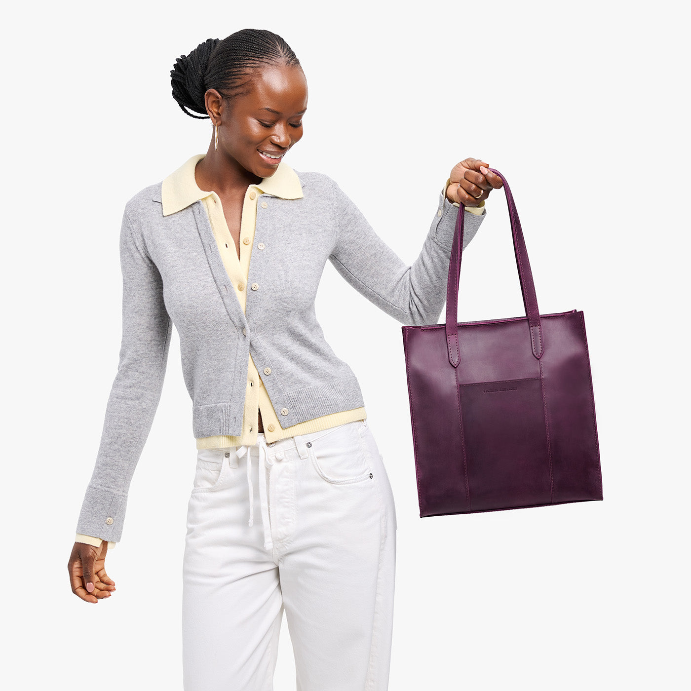 Larkspur*North/South | Model holding structured large tote bag with overlapping panels and crossbody strap