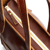 Nutmeg North/South | Model holding structured large tote bag with overlapping panels and crossbody strap