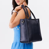 Night Owl North/South | Model wearing structured large tote bag with overlapping panels and crossbody strap