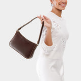 Chocolate Brown Small | Model holding petite bean shaped shoulder bag with a zipper closure