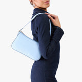 Skyway | Model carrying petite bean shaped shoulder bag with a zipper closure