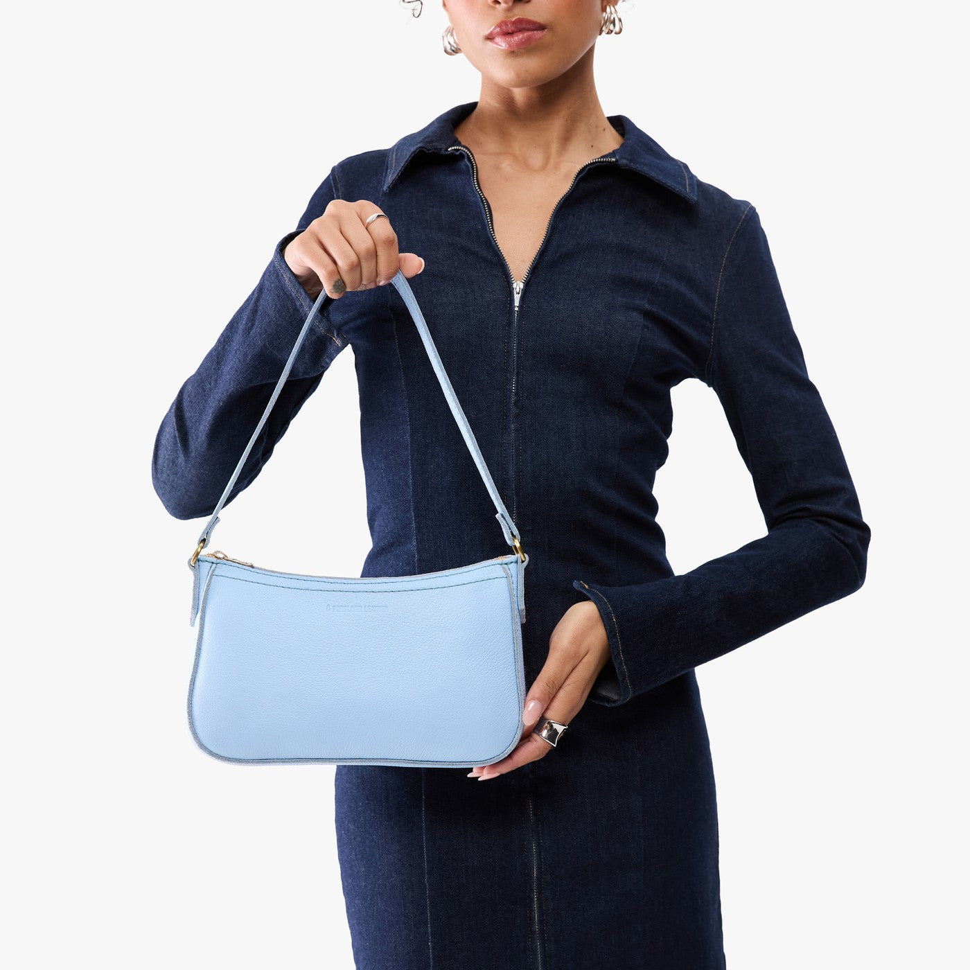 Skyway | Model carrying petite bean shaped shoulder bag with a zipper closure