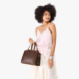 Coldbrew Medium | Model carrying leather tote bag with handles, adjustable crossbody strap, and two back pockets