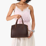 Coldbrew Medium | Model carrying leather tote bag with handles, adjustable crossbody strap, and two back pockets