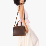 Coldbrew Medium | Model carrying leather tote bag with handles, adjustable crossbody strap, and two back pockets