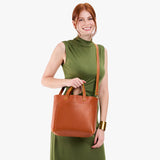 Sienna Classic | Model holding midsize crossbody tote with handles and a pocket