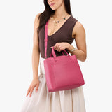 Wild Rose Classic | Model holding midsize crossbody tote with handles and a pocket