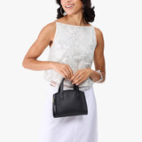 Black Mini | Model holding small leather tote bag with handles, adjustable crossbody strap, and one back pocket