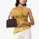 Moose Mini | Model carrying small leather tote bag with handles, adjustable crossbody strap, and one back pocket