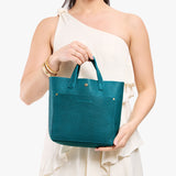 Aquarius Classic | Model holding crossbody tote bag with snap closure and front pocket