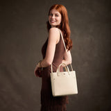 Pebbled Bone Classic | Model carrying crossbody tote bag with snap closure and front pocket