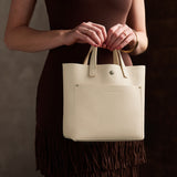 Pebbled Bone Classic | Model carrying crossbody tote bag with snap closure and front pocket