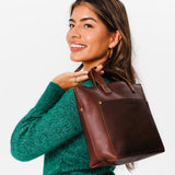 Cognac Zipper | Model holding crossbody tote bag with zipper closure and front pocket