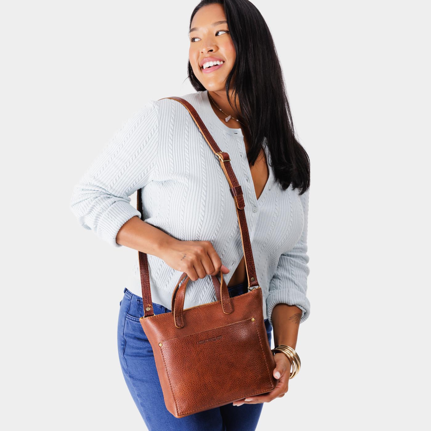 Nutmeg*Zipper | Model holding crossbody tote bag with zipper closure and front pocket