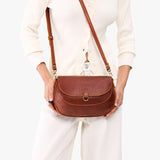 Nutmeg Large | Model wearing a leather Crossbody with a flap and magnetic closure