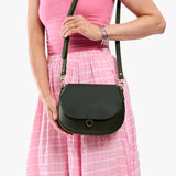 Evergreen Small | Model wearing a petite leather Crossbody with a flap and magnetic closure