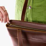 Cognac Medium Zipper  | Model wearing leather tote bag with riveted straps and exterior key loop