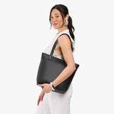 Pebbled--black Medium Zipper | Model wearing leather tote bag with riveted straps and exterior key loop