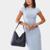 Night Owl Large | Model wearing mid-size shoulder bag with adjustable strap and magnetic snap closure