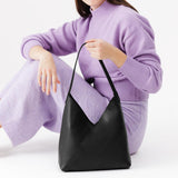 Pebbled--black Large | Model holding mid-size shoulder bag with magnetic snap closure