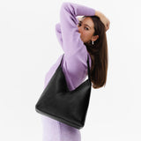 Pebbled--black Large | Model wearing mid-size shoulder bag with magnetic snap 