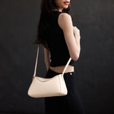 Pebbled Bone Small | Model wearing a leather Crossbody with a flap and magnetic closure