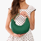 Bacalar | Model with a crescent shaped shoulder bag with zipper closure and gold accents