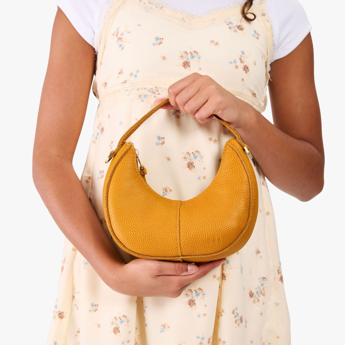Sunshine | Model with a crescent shaped shoulder bag with zipper closure and gold accents