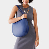 Molino Blue Large | Woman wearing rounded shoulder bag with adjustable strap on a white background