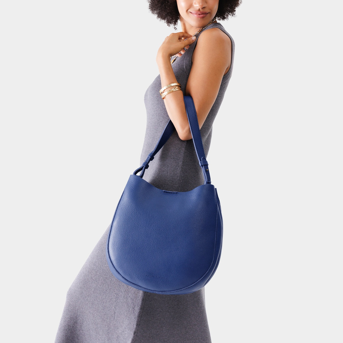 Molino Blue*Large | Woman wearing rounded shoulder bag with adjustable strap on a white background