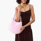 Pinkaboo Medium | Model carrying round leather purse with adjustable shoulder strap