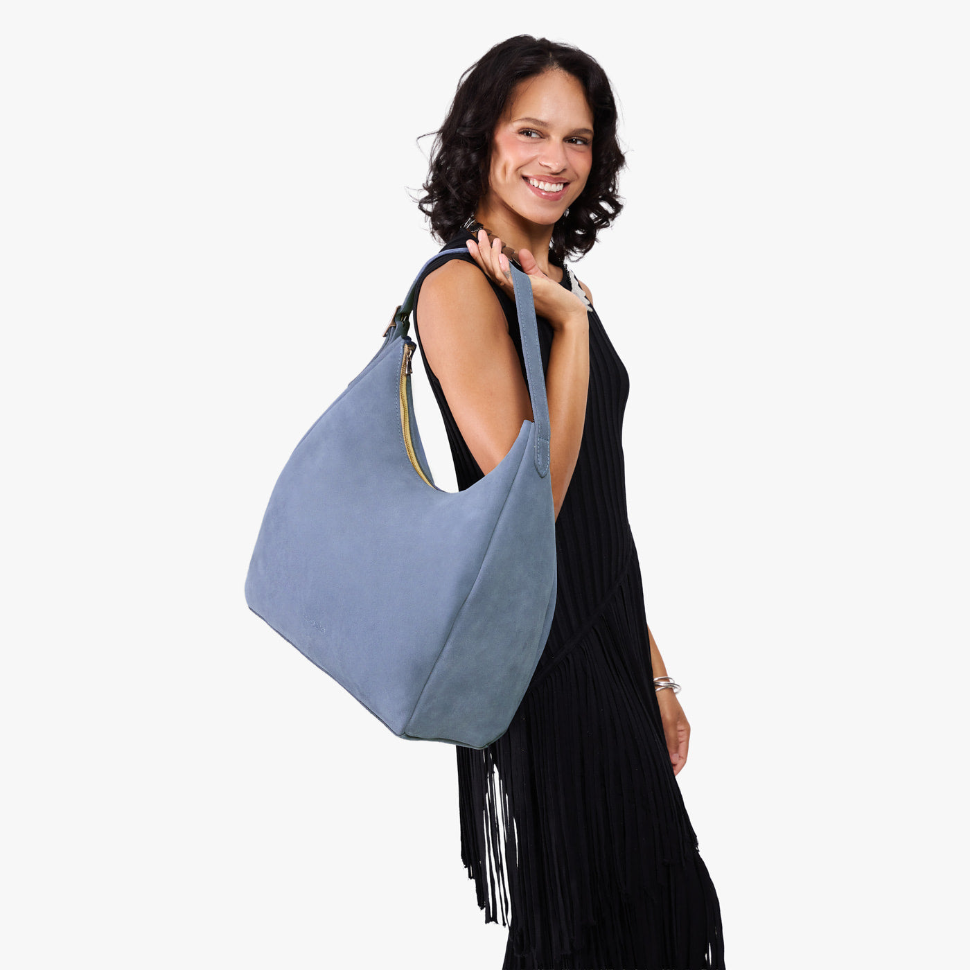 Denim*Oversized | Model holding u-shaped, flat-bottomed leather shoulder bag with adjustable strap