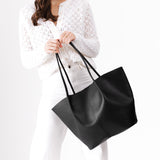 Black Oversized | Model holding extra wide bucket shaped tote bag with matching leather handles