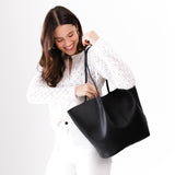 Black Oversized | Model holding extra wide bucket shaped tote bag with matching leather handles