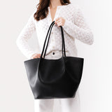 Black Oversized | Model holding extra wide bucket shaped tote bag with matching leather handles
