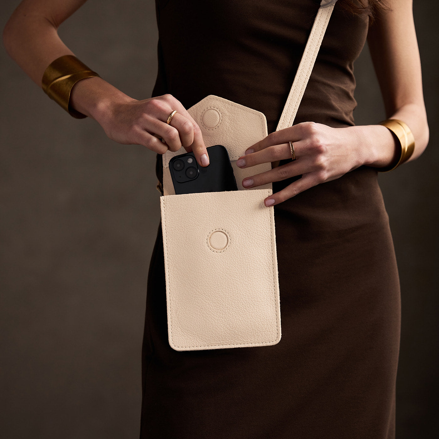 Pebbled Bone | Model wearing slim, phone-shaped crossbody purse with magnetic closure