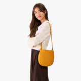 Sunshine | A model wearing a rounded children's adjustable crossbody bag