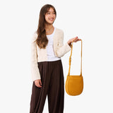 Sunshine | A model wearing a rounded children's adjustable crossbody bag