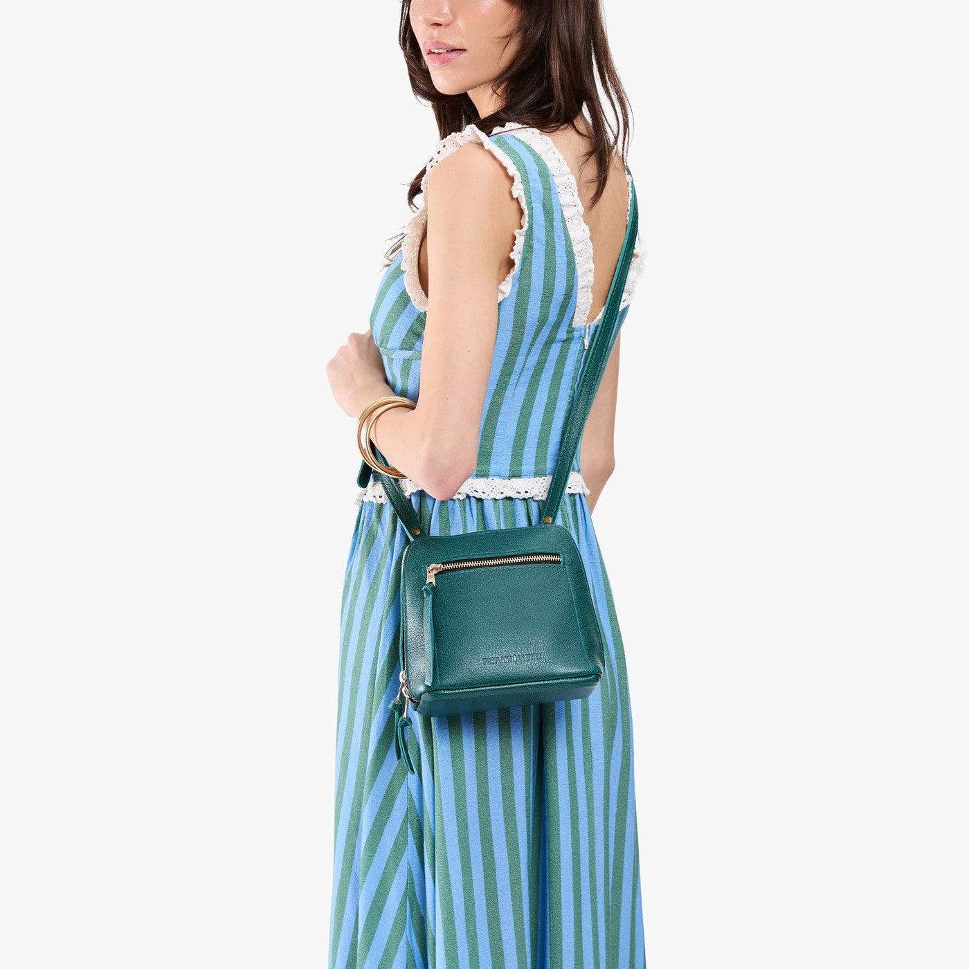 Sea Glass*Small | Model carrying compact leather bag with top zipper, front zipper pocket, and adjustable crossbody strap