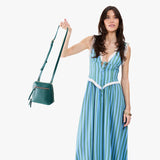 Sea Glass Small | Model carrying compact leather bag with top zipper, front zipper pocket, and adjustable crossbody strap