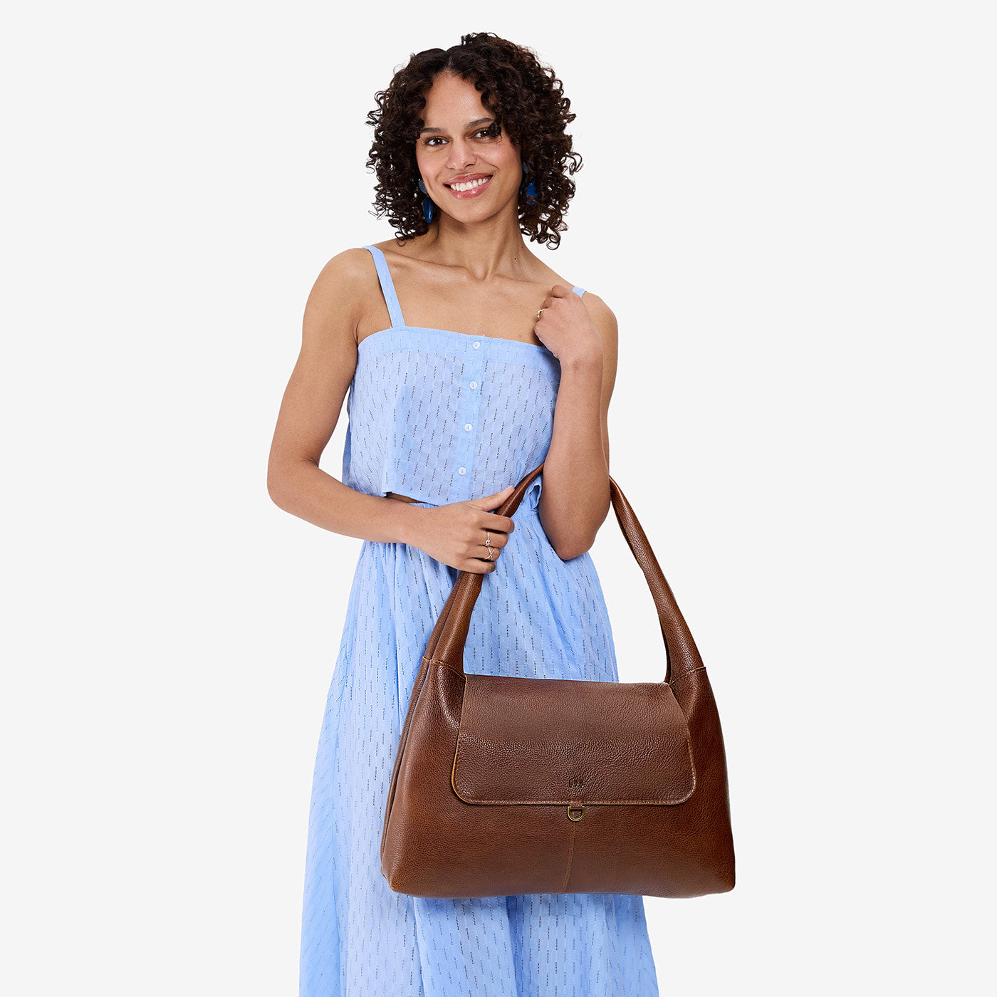 Asheville*Large | A model holding a slouchy triangle shaped shoulder bag with a flap