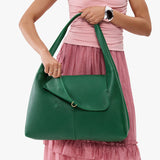 Bacalar Large | A model holding a slouchy triangle shaped shoulder bag with a flap