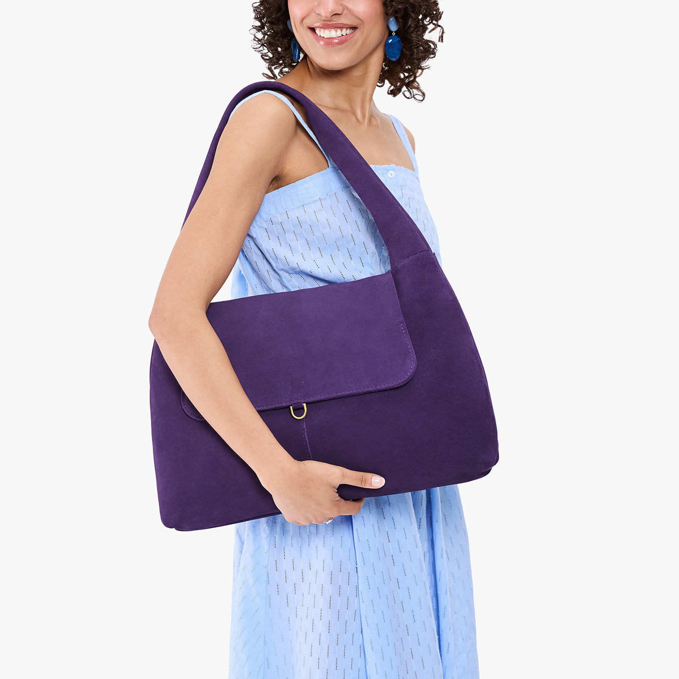 Imperial*Large | A model holding a slouchy triangle shaped shoulder bag with a flap