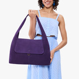 Imperial Large | A model holding a slouchy triangle shaped shoulder bag with a flap