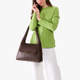 Coldbrew Medium | A model holding a slouchy triangle shaped shoulder bag with a flap