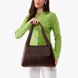 Coldbrew Medium | A model holding a slouchy triangle shaped shoulder bag with a flap