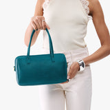 Aquarius Large | Model holding mini duffle shaped handbag with crossbody strap